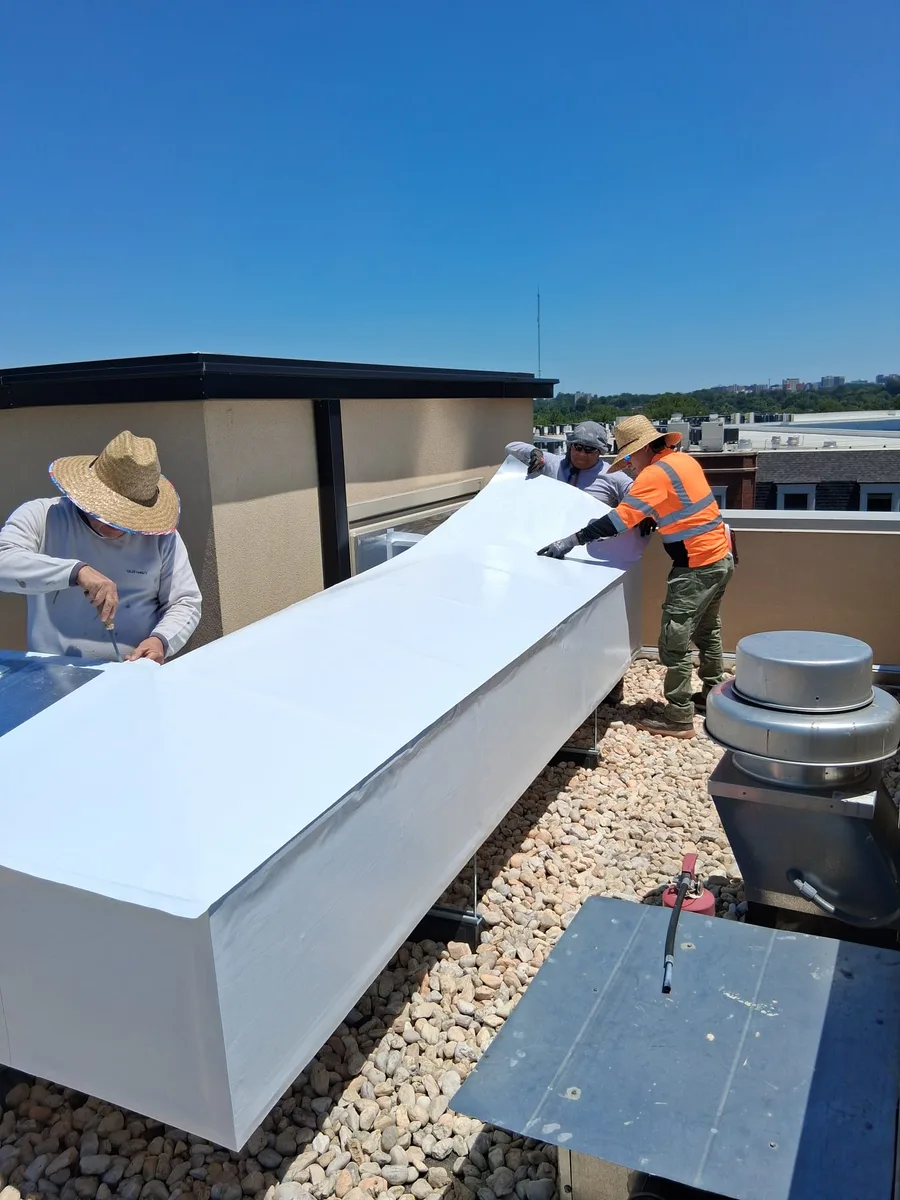 Dos instaladores rematando forro de PVC sobre ductos