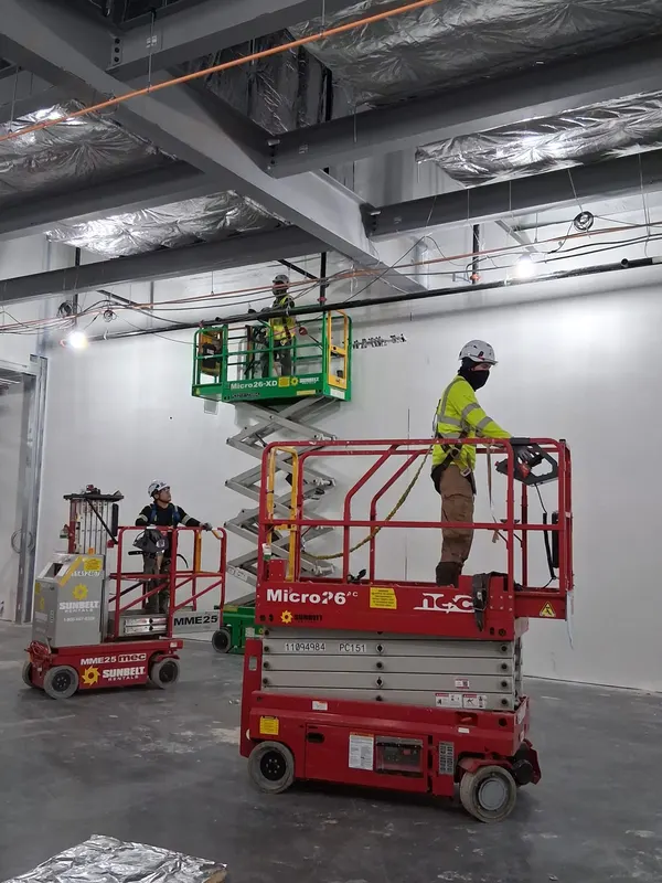 Elevadores de la cuadrilla dentro de un edificio comercial en obra